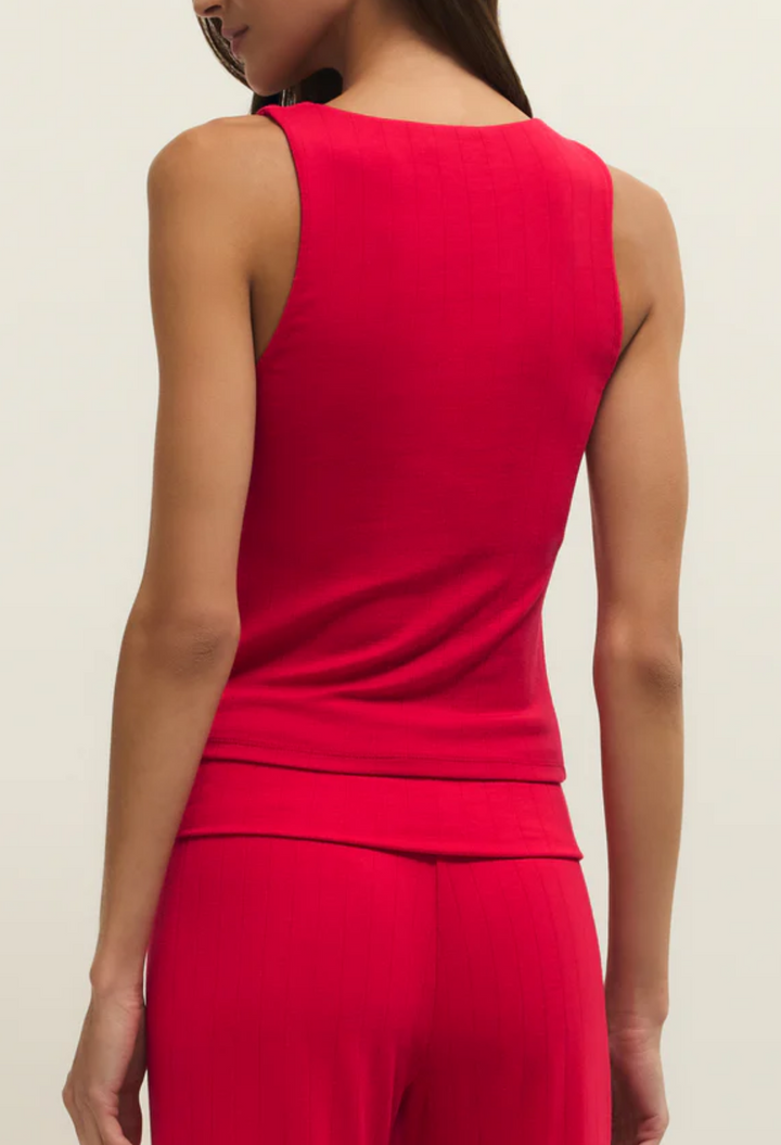 Woman wearing a red jumpsuit on a beige background