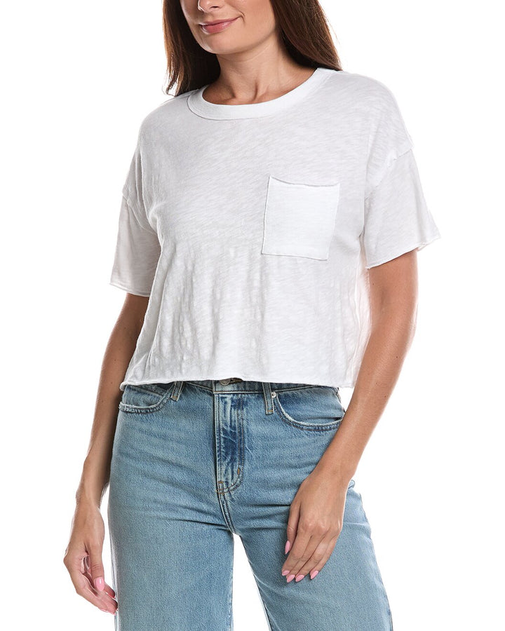 A woman wearing a white short-sleeve cropped t-shirt with a chest pocket and light blue jeans, shown from the nose down against a plain white background.