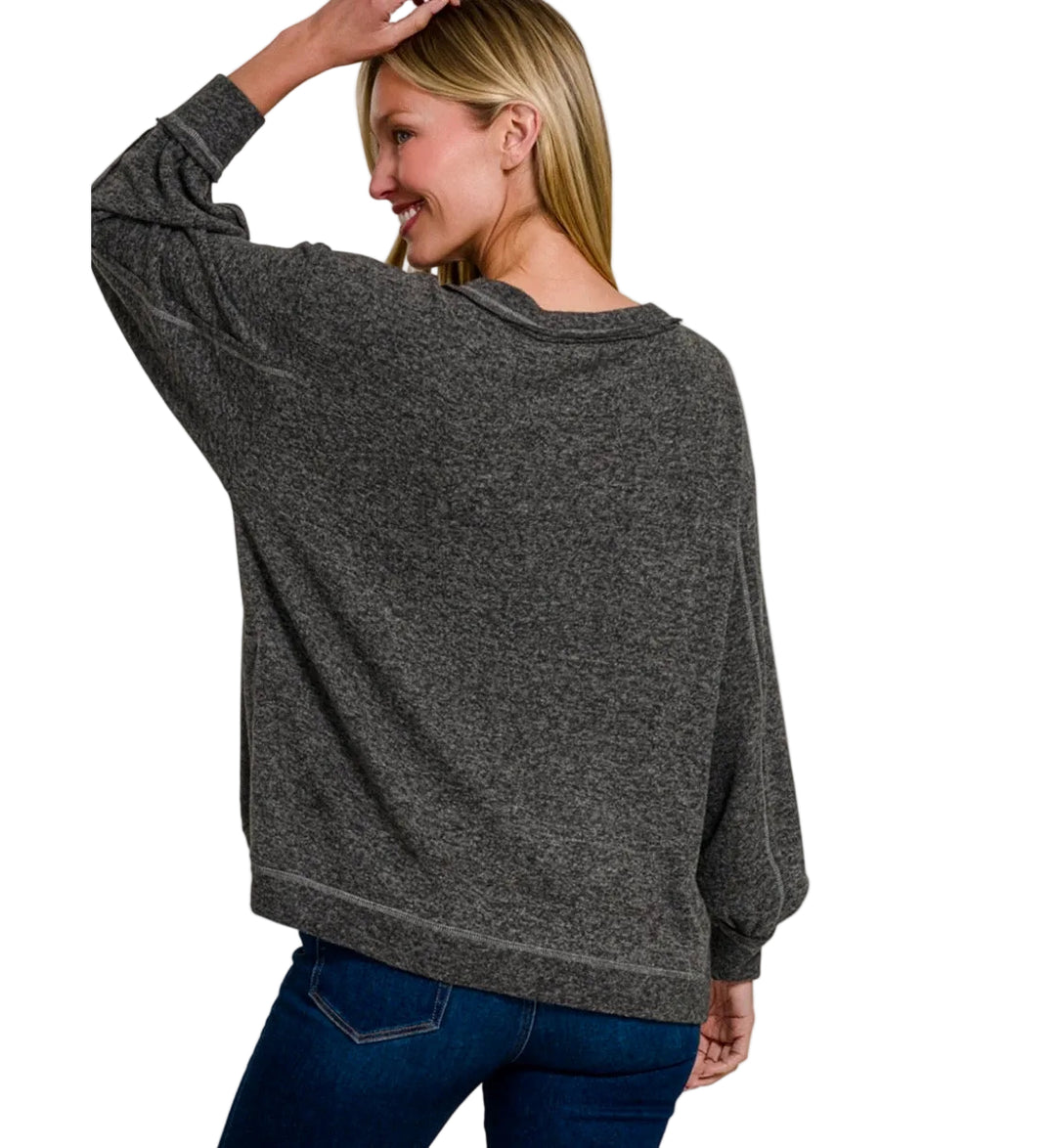 A woman wearing a dark heather gray long-sleeve top, shown from the back against a plain white background. 