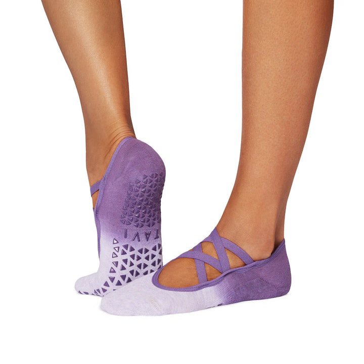 Purple yoga socks with textured sole worn by a person on a white background