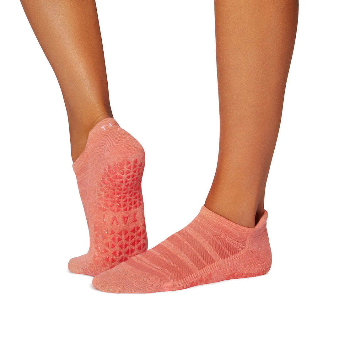 Pink grip socks worn by a person on a white background