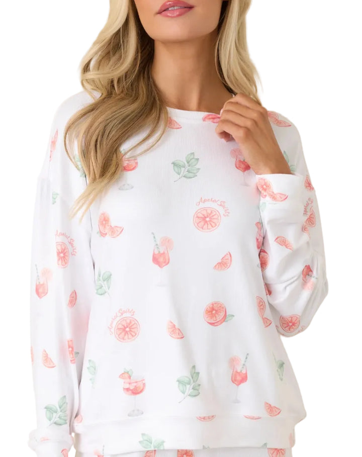 Woman wearing a white long-sleeve shirt with floral pattern on a beige background