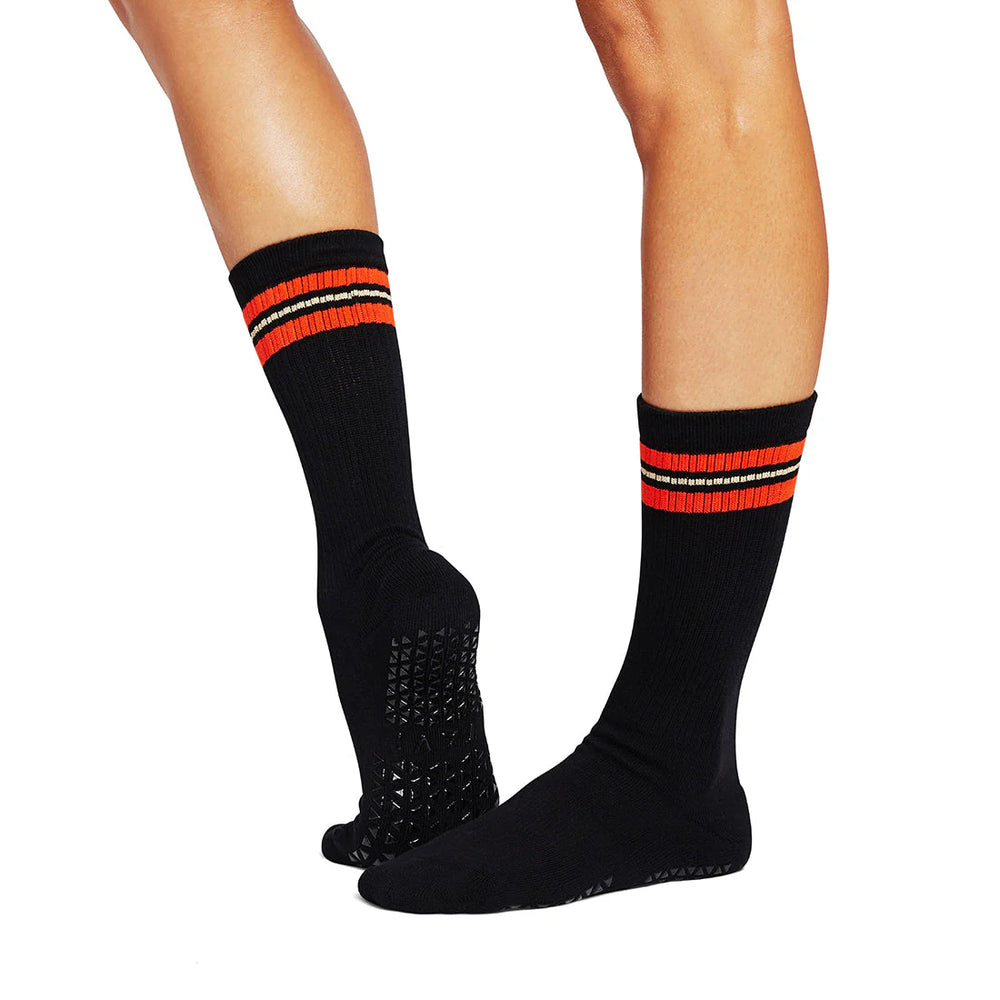 Black socks with red and white stripes worn by a person on a white background