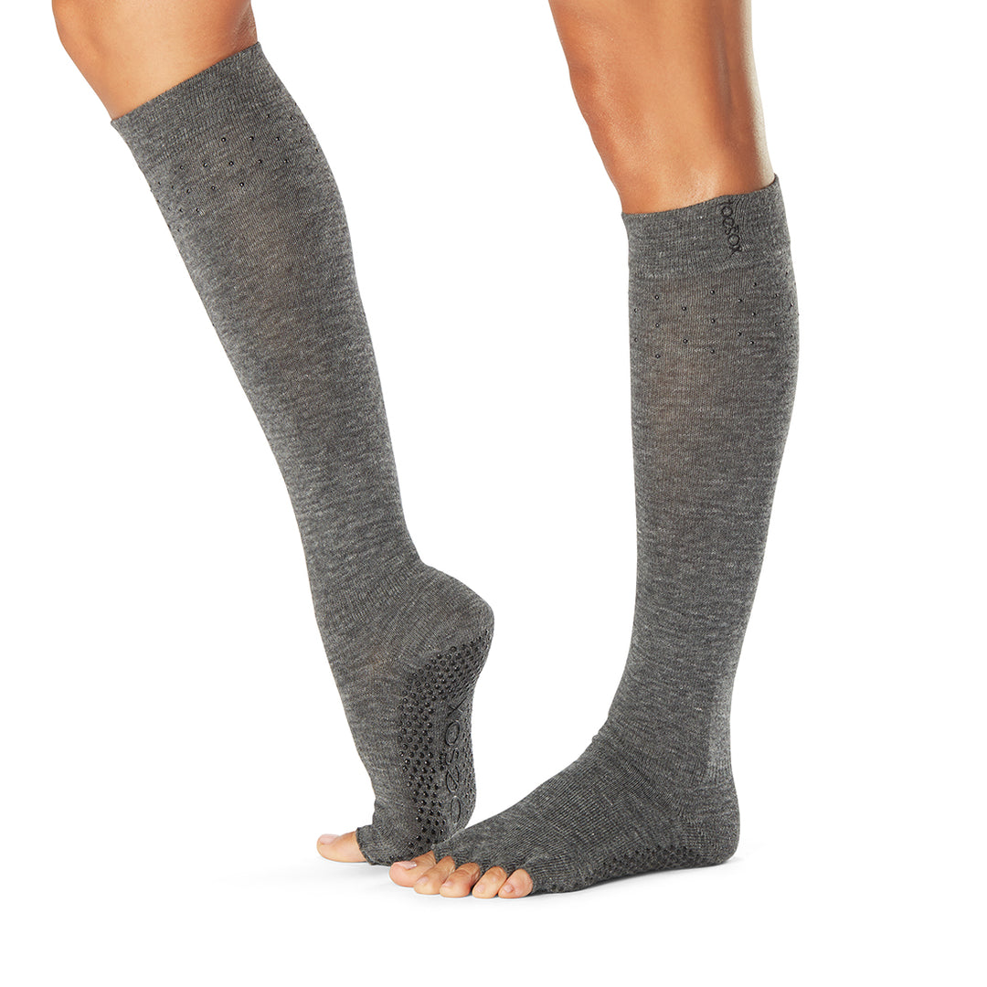 Gray knee-high socks worn by a person on a white background