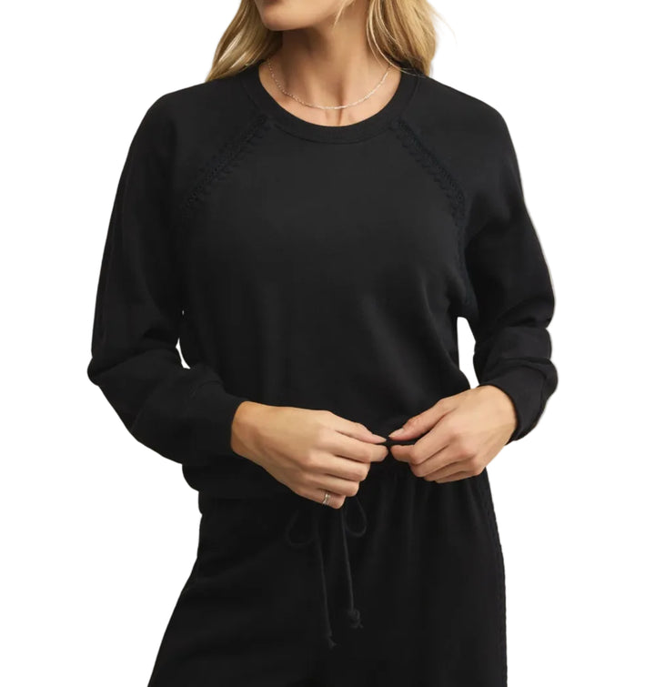 Woman wearing a black sweatshirt against a white background