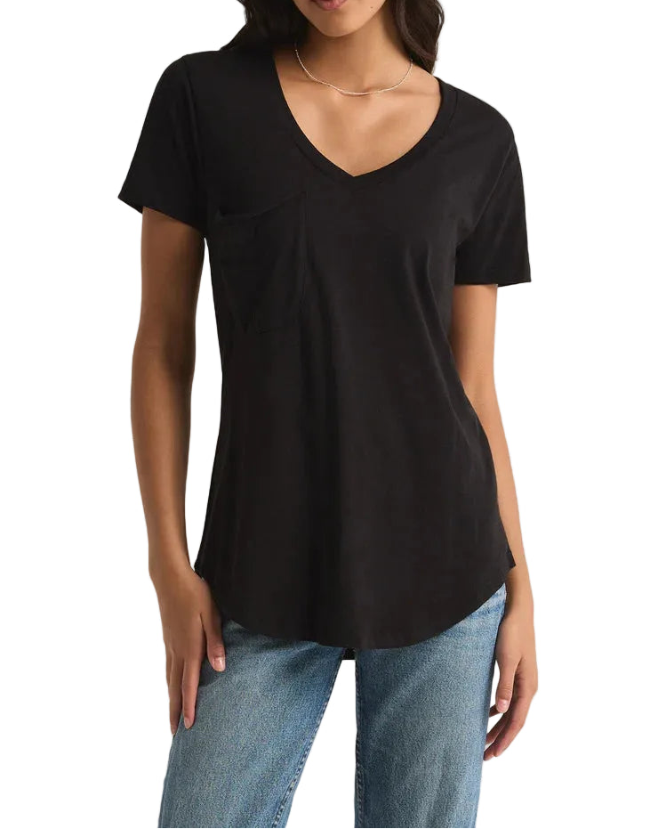 Woman wearing a black t-shirt and blue jeans on a plain background