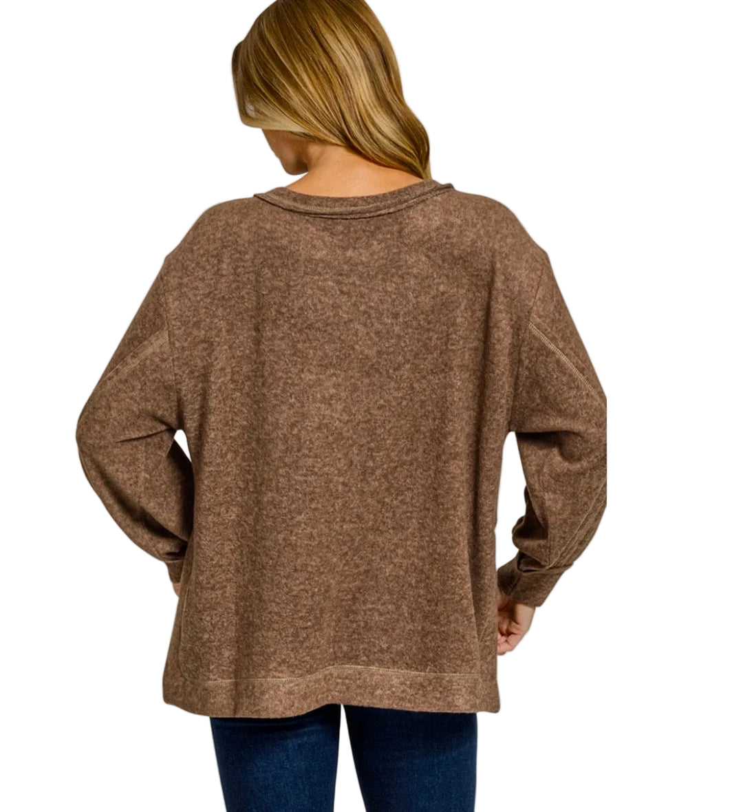 A woman shown from the back wearing a brown long-sleeve knit top and blue jeans against a light gray studio background. The word 'BROWN' appears in the bottom right corner.