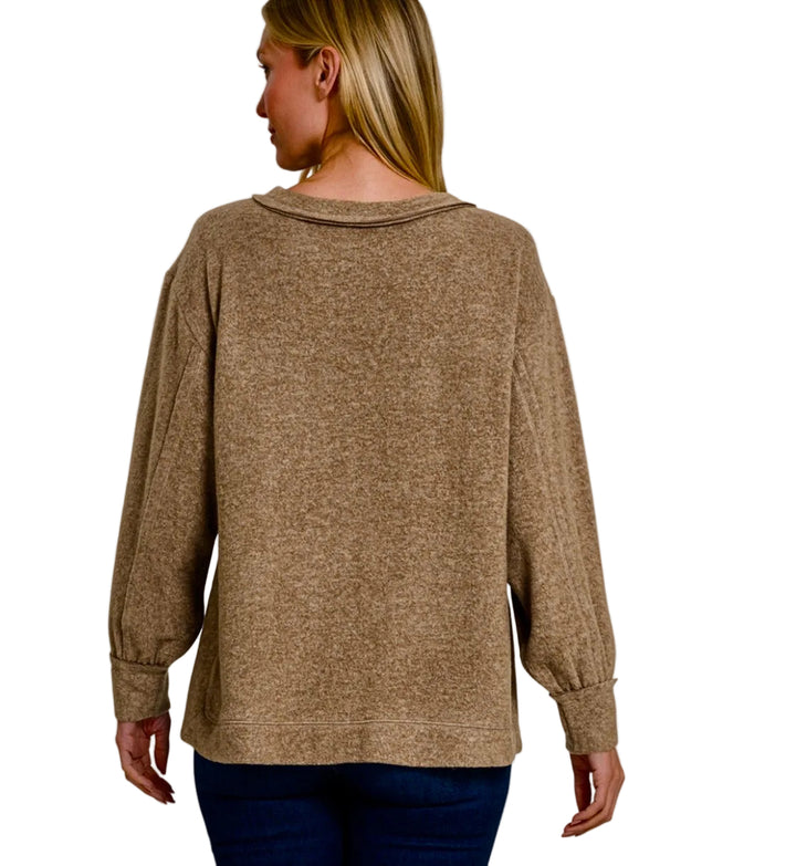A woman shown from the back wearing a long-sleeve mocha brown sweater, with text overlays reading 'BRUSHED MCKINNEY SOFT' and 'MOCHA' on a light gray background.