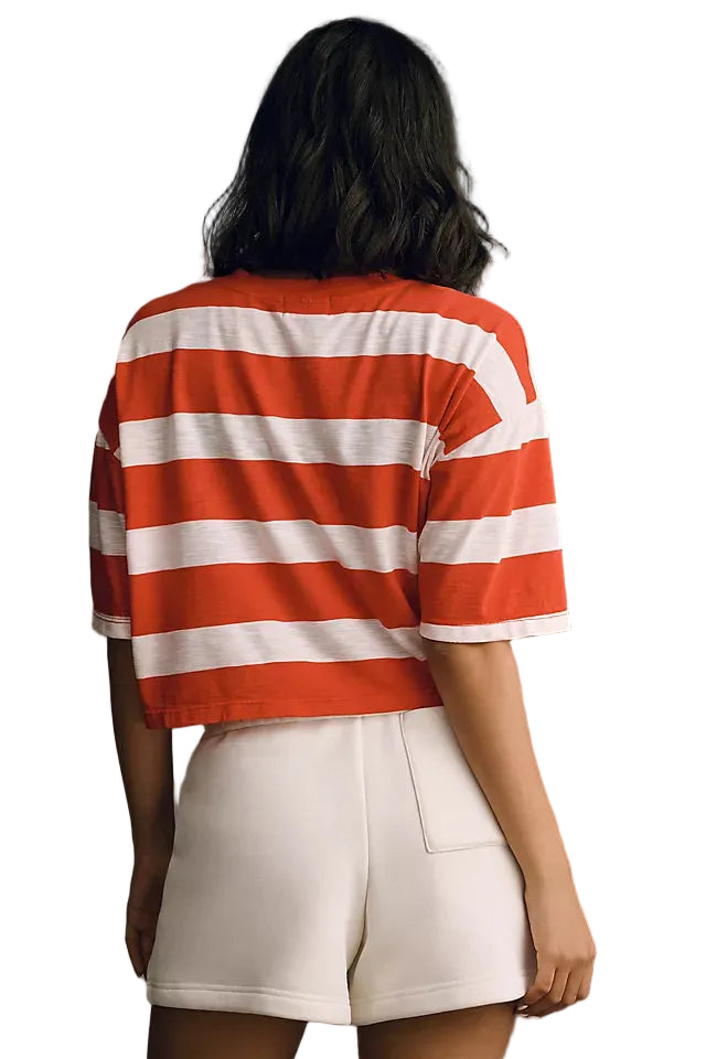 Person wearing a red and white striped shirt and white shorts against a gray background