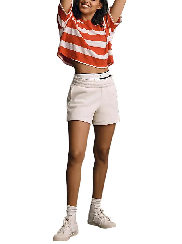 Person wearing a red and white striped shirt and white shorts on a gray background